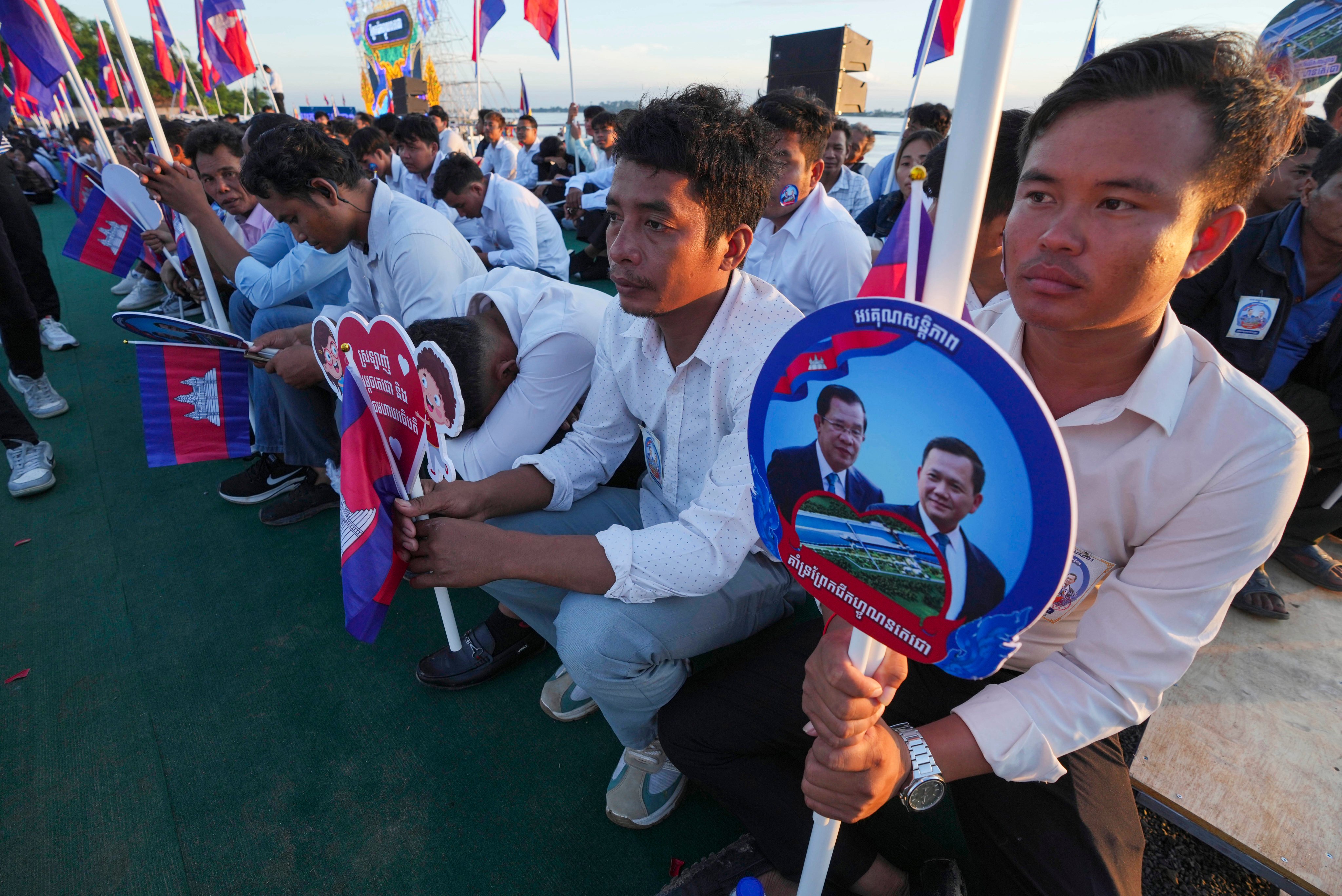 Cambodians hold photographs of their Prime Minister Hun Manet and his father Hun Sen at a groundbreaking ceremony of the China-funded Funan Techo canal. Photo: AP