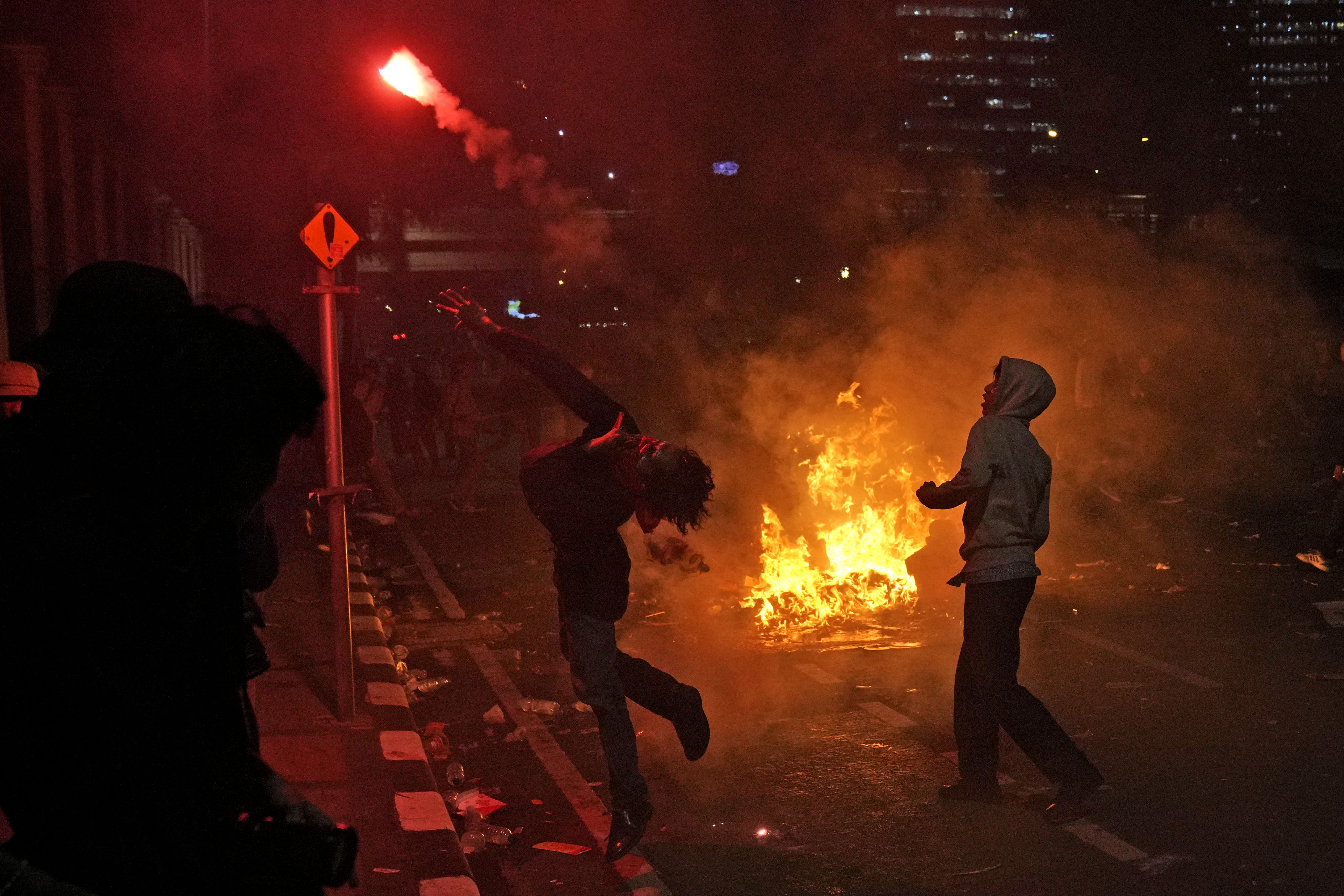 A student protester throws a flare at riot police during a rally on Thursday last week against controversial changes to Indonesia’s election laws. Photo: AP 