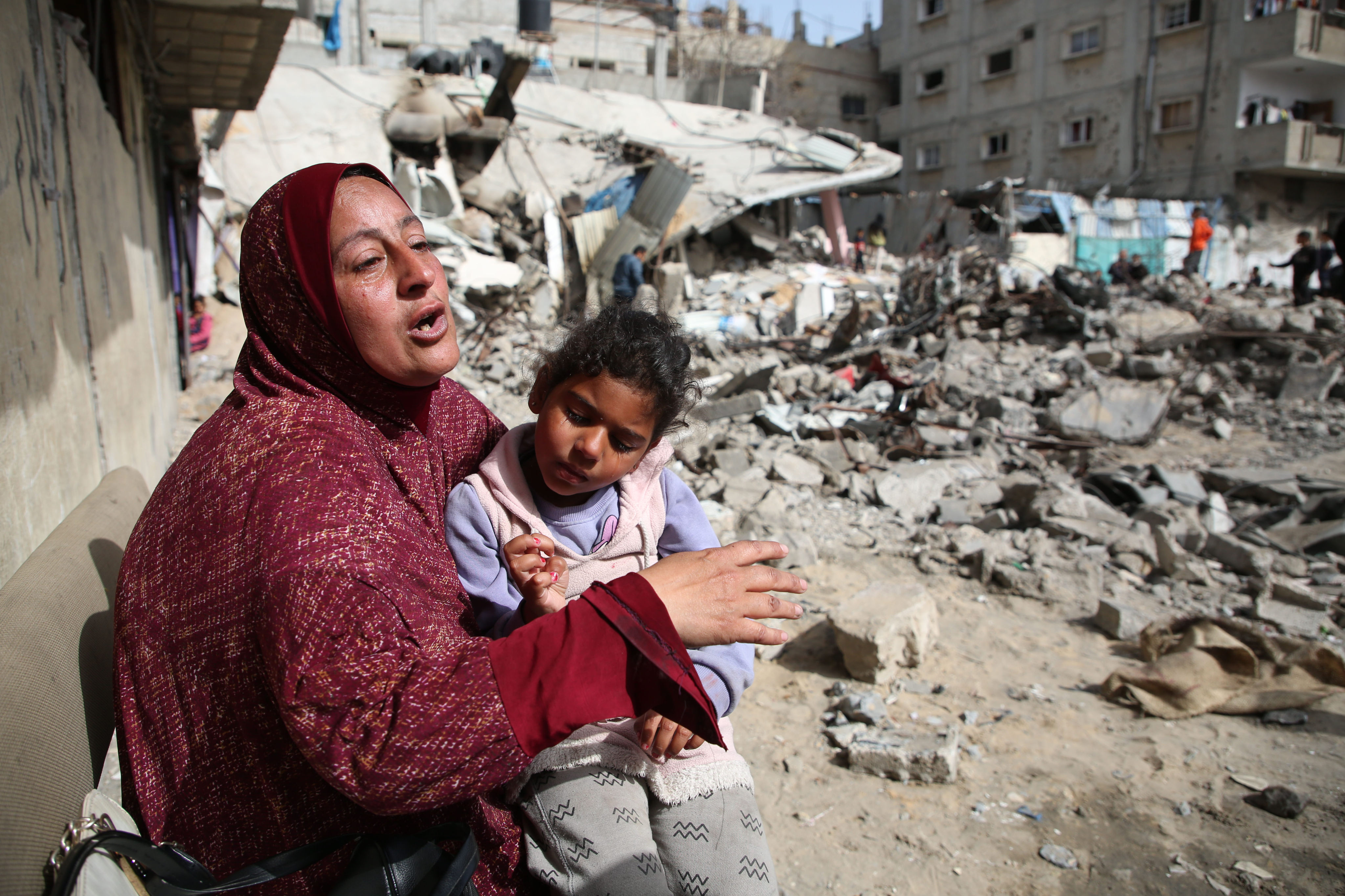 A woman sits near the rubble of a building destroyed in an Israeli airstrike in the Gaza city of Rafah on March 27. Photo: Xinhua