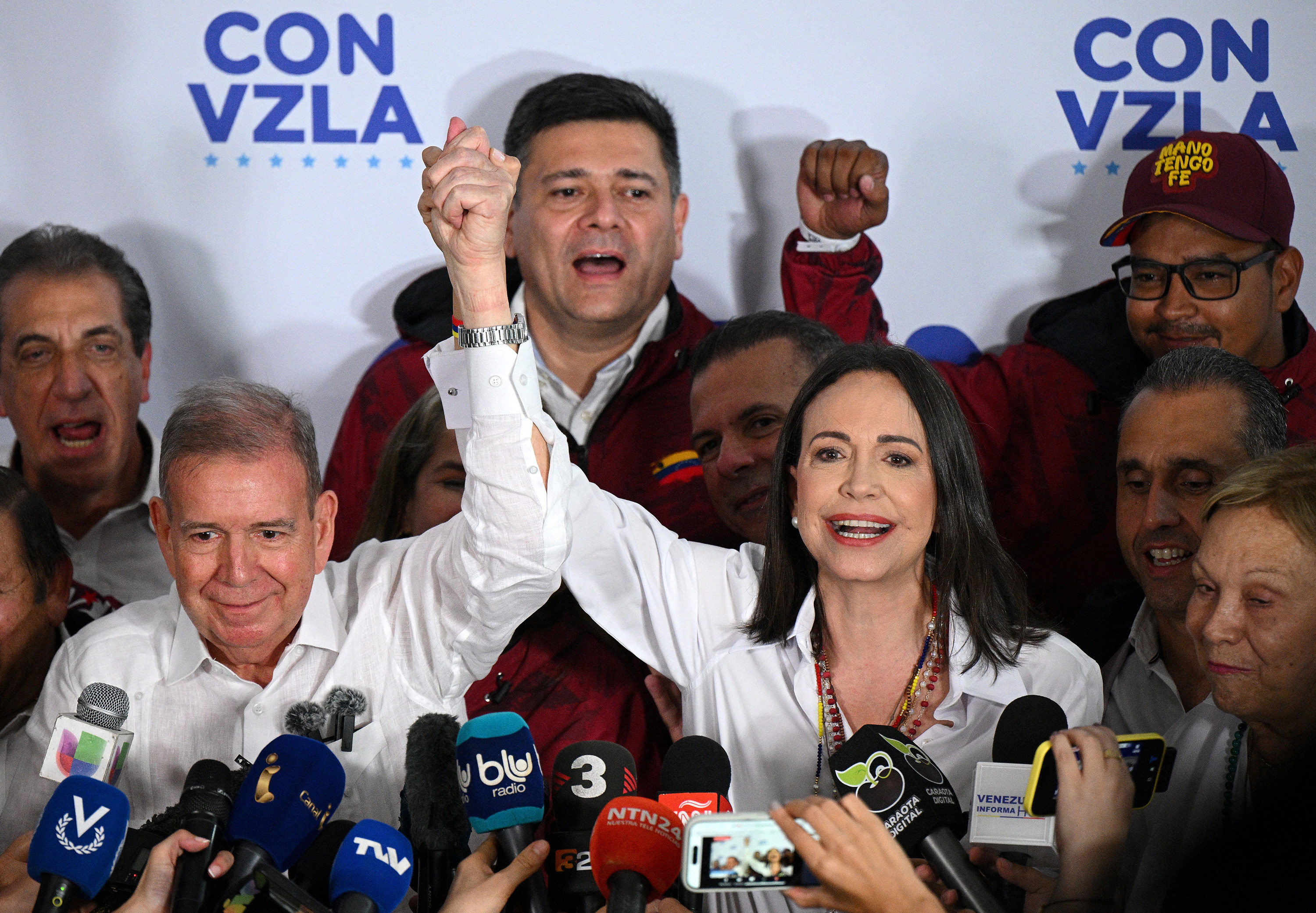 Venezuelan opposition leader Maria Corina Machado, right, raises the arm of opposition presidential candidate Edmundo Gonzalez Urrutia in Caracas on July 28. Photo: AFP / Getty Images / TNS