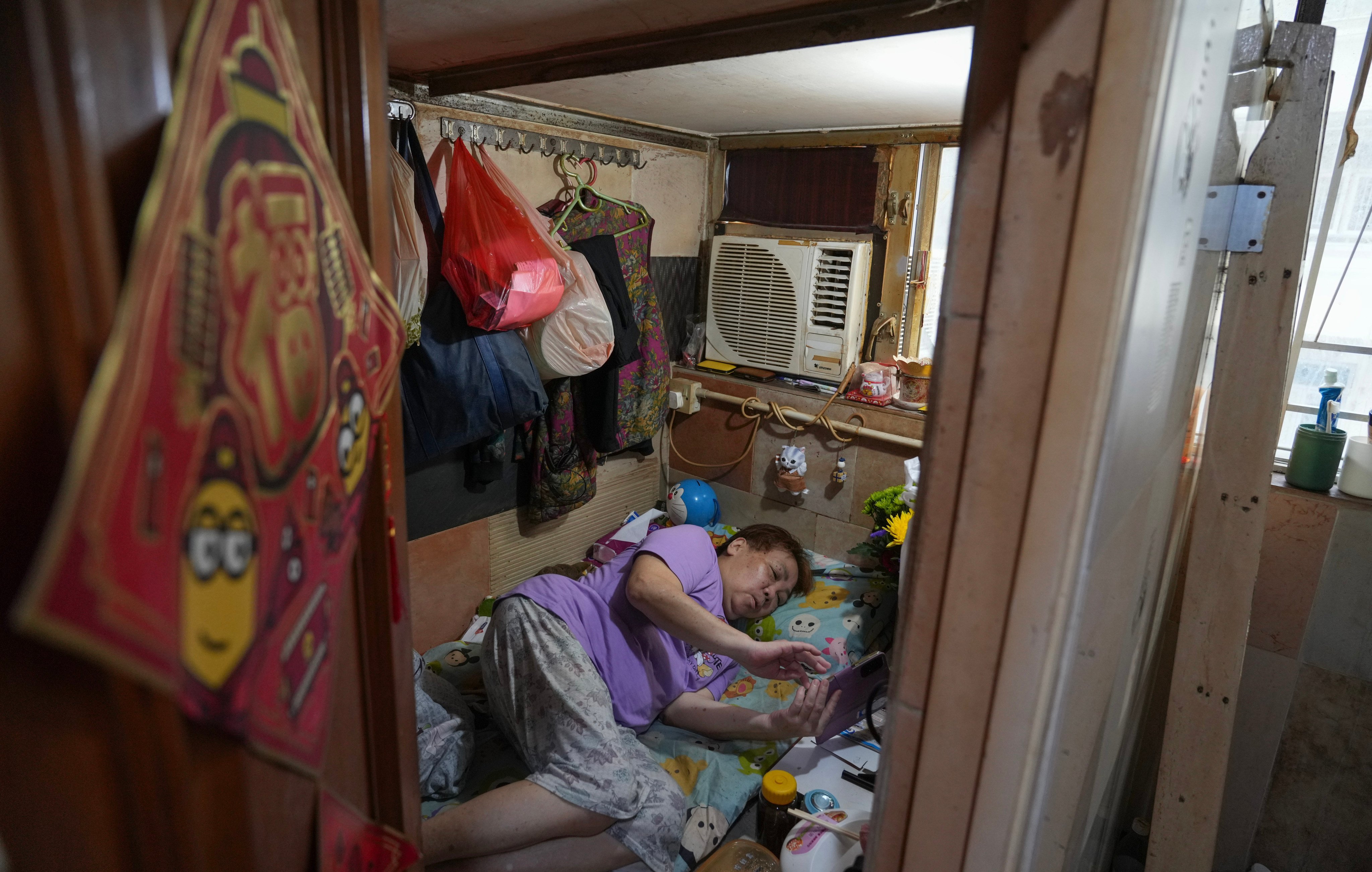 A resident is seen in a subdivided flat in Mong Kok in July. Photo: Sam Tsang